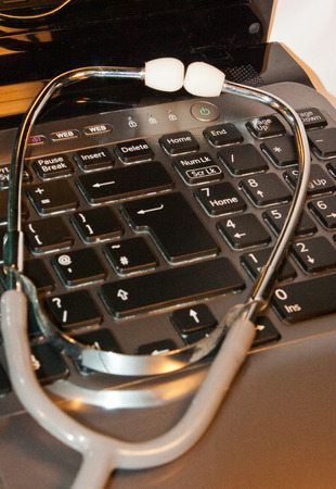 A stethoscope on top of a open laptopの写真素材