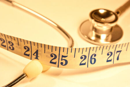 Close up of stethoscope and measuring tapeの写真素材