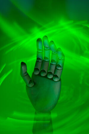 A wooden hand surrounded by a neon green light