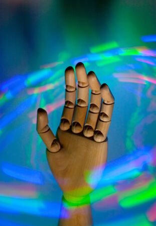 A wooden hand in the midst of swirling neon lightsの写真素材