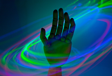 A wooden hand in the midst of swirling neon lightsの写真素材