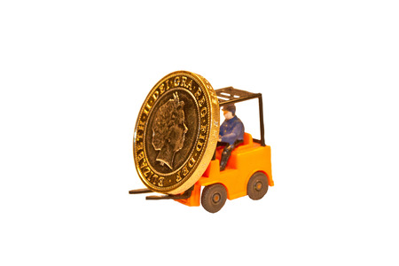 A toy fork lift truck lifting up a British two pound coinの写真素材