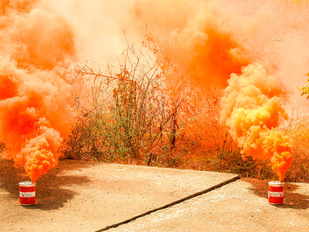 A bright orange smoke grenade used to signal in the event of rescue or to show a position from far away.の写真素材