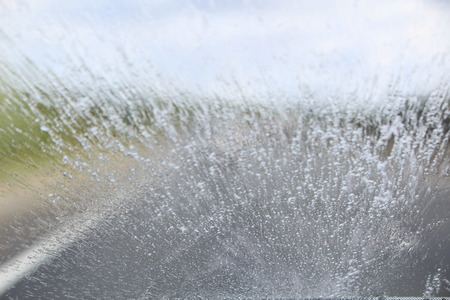 An obscured view from the driver's seat as heavy rain batters down on a car windscreen.の写真素材