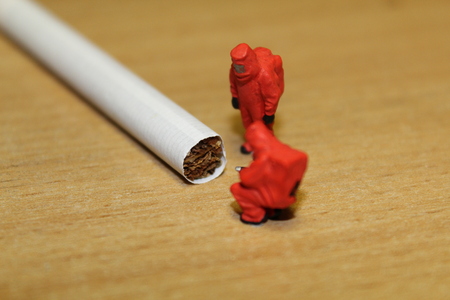 Two people in chemical suits inspect a cigarette.の写真素材