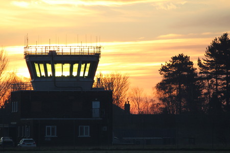 A beautiful view across an airport Air Traffic Control tower as the sun rises in the background.の写真素材