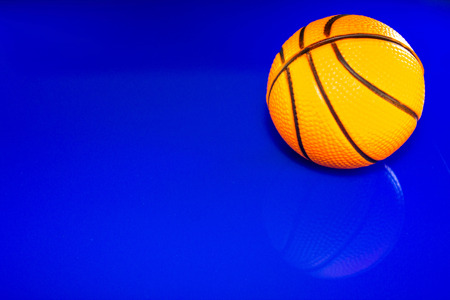 A closeup of a basketball, against a reflective blue background.の写真素材