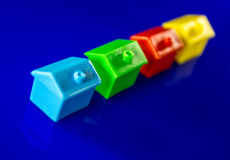 A blue background with plastic houses as the main focus.の写真素材
