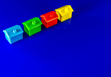 A blue background with plastic houses as the main focus.の写真素材