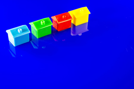 A blue background with plastic houses as the main focus.の写真素材