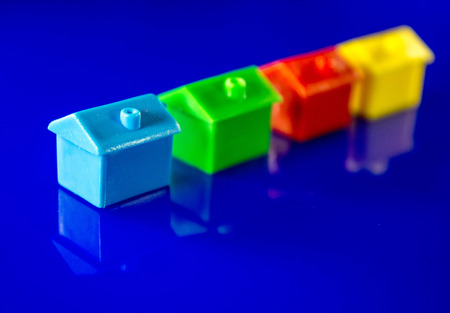 A blue background with plastic houses as the main focus.の写真素材