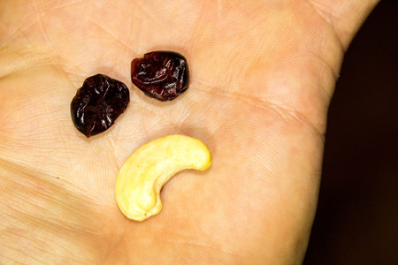 A mix of fruit and nut to give an expression on the palm of a hand.の写真素材