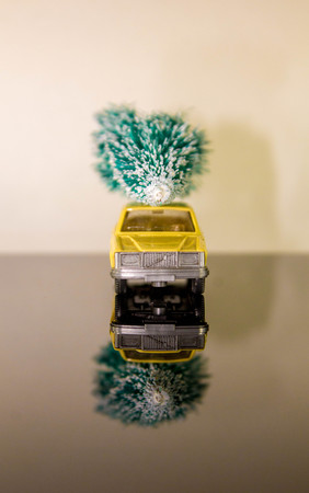 A car against a blank background sits with a lovely green Christmas tree on the roof.の写真素材