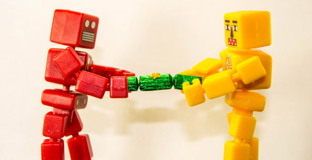 Two robot people battle to win at pulling a Christmas Cracker.の写真素材