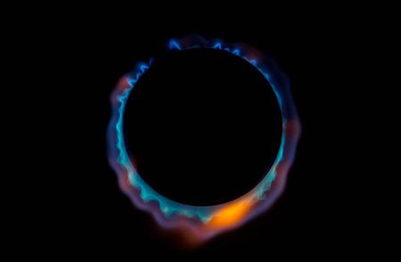 A bright neon blue flame emitting from a cooker hob.の写真素材