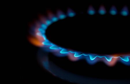 A bright neon blue flame emitting from a cooker hob.の写真素材