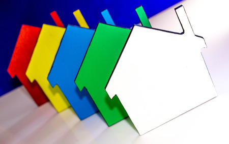 A stack of coloured houses against a plain background.の写真素材