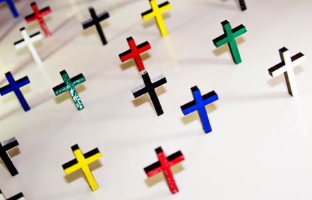 Christian crucifix crosses standing on a solid colour background.