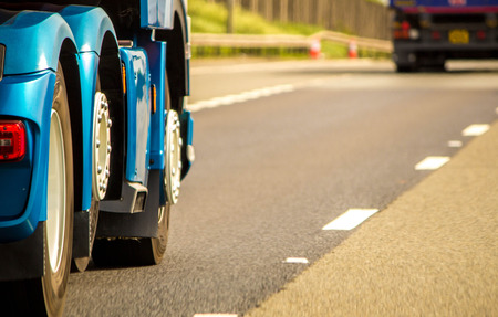 A closeup of wheels in motion from an articulated lorry, travelling along a UK motorway.