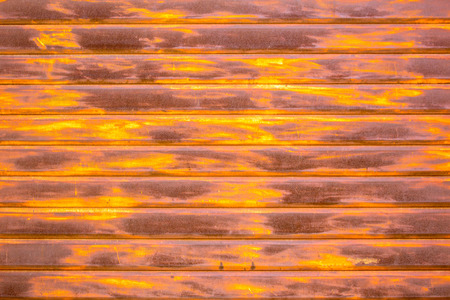 A closeup of brown rusty shutters on a store or garage front.の写真素材