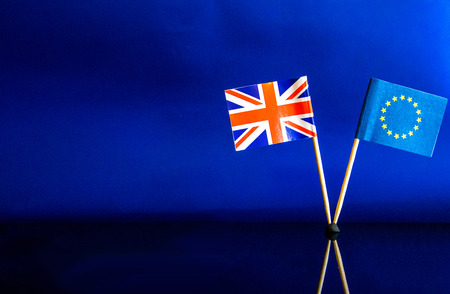 The British and EU flags stand together, against a sky blue background.の写真素材