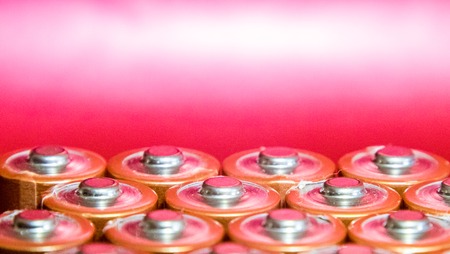 A collection of pencil AA batteries, taken close up at their heads.