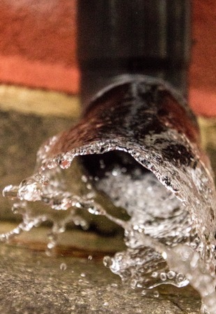 Gutters gush with water from a heavy downpour of rain.