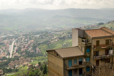 A view from Enna, just of the of the many beautiful towns of Sicily, Italy. A single rooftop in the foreground.の写真素材