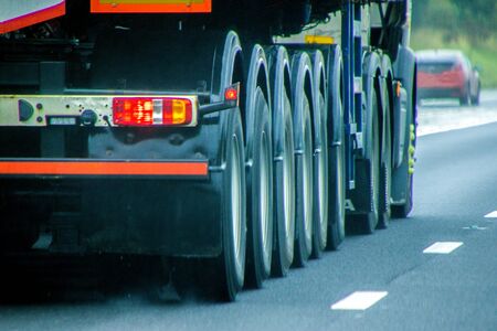 A closeup of wheels in motion from an articulated lorry, traveling along a UK motorway.