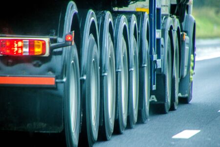 A closeup of wheels in motion from an articulated lorry, traveling along a UK motorway.