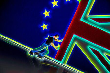 A plastic figure pushes against the flag of the United Kingdom to keep the EU flag visible.の写真素材