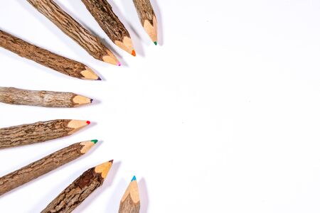 A set of colourful wooden art pencils laid out on a white background.