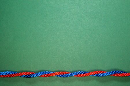 Colourful primary coloured string twisted on a bright blue background.