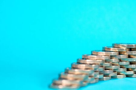 A stack of Pound Coins on a bright blue background.の写真素材