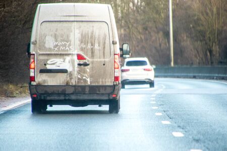 A 'white' van that has had a festive message written in the dirt, on it's back doors.の写真素材