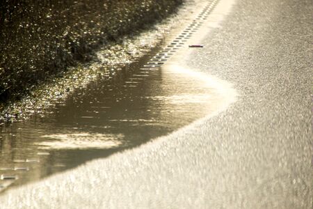 A main road through part of the United Kingdom is coned off to protect drivers from driving through a flooded lane.の写真素材