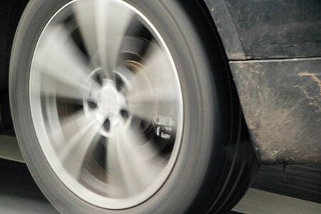 A close up of a vehicle wheel whilst it is in motion.