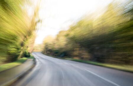 A view along a main road with motion blur showing the movement of traffic and the vehicle being...