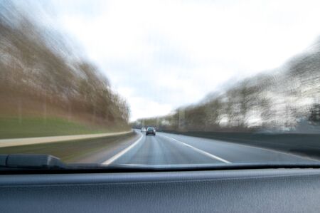 A view along a main road with motion blur showing the movement of traffic and the vehicle being...