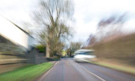 A view along a main road with motion blur showing the movement of traffic and the vehicle being driven.の写真素材