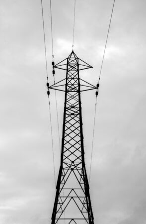 A typical electricity pylon in the United Kingdom. These steel structures hold thick cables that transfer electricity across the land.の写真素材