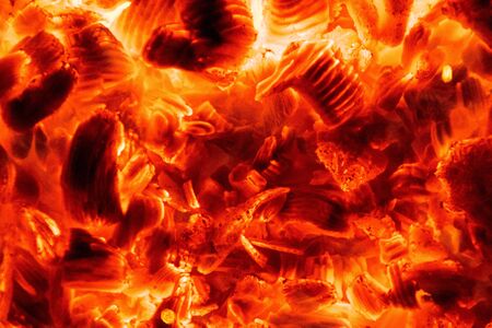 A look deep into a well lit fire. Orange, red and black emmitting due to the heat and flames of a...