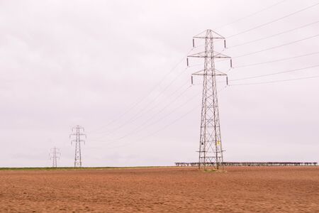 A long stretch of pylons take vital electricity to towns and cities across the United Kingdom.の写真素材