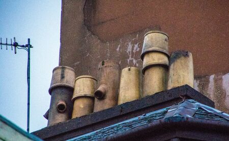 A group of chimney pots stacked together on a rooftop.