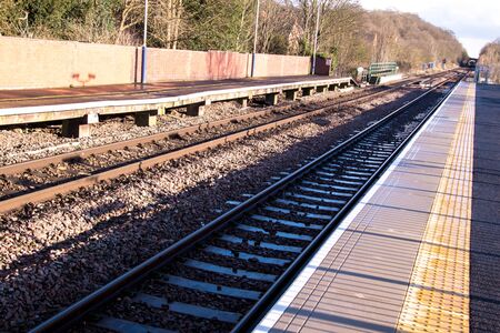 A view along a new train station platform during a sunny day.