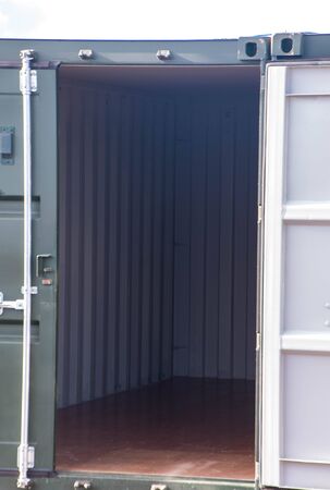 A row of storage containers with the sun setting in the background.