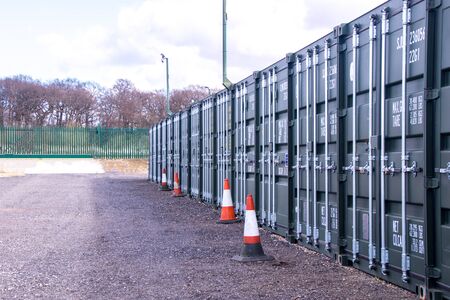 A row of storage containers with the sun setting in the background.