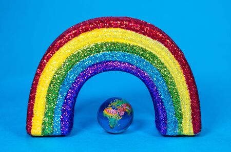 The planet Earth along with a colorful rainbow colored ribbon which signifies many things, such as the Coronavirus pandemic.の写真素材
