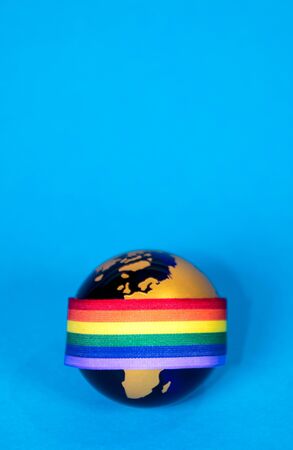 The planet Earth along with a colorful rainbow colored ribbon which signifies many things, such as the Coronavirus pandemic.の写真素材