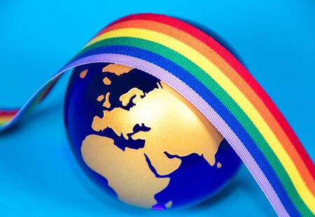 The planet Earth along with a colorful rainbow colored ribbon which signifies many things, such as the Coronavirus pandemic.の写真素材